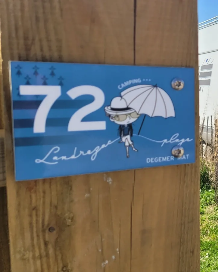 Le panneau bleu de l’emplacement 72, fixé sur un poteau en bois