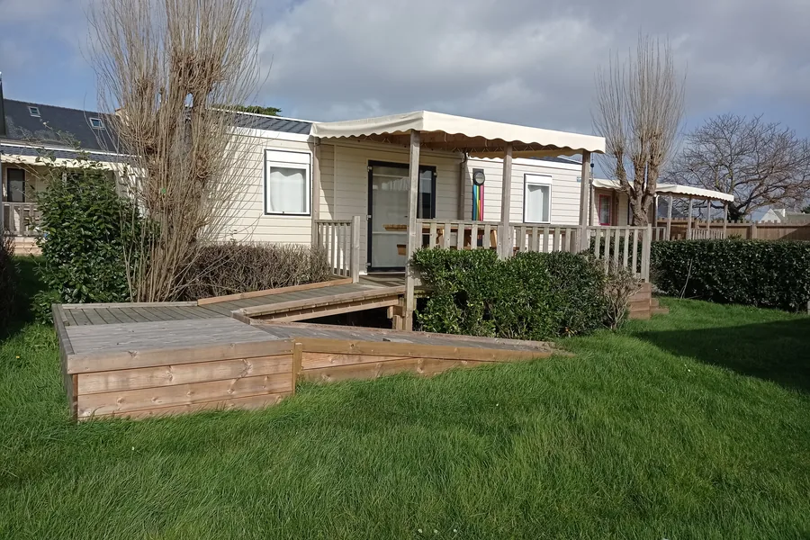 Le mobil-home Glenans, avec une longue rampe en bois qui monte jusqu’à sa terrasse