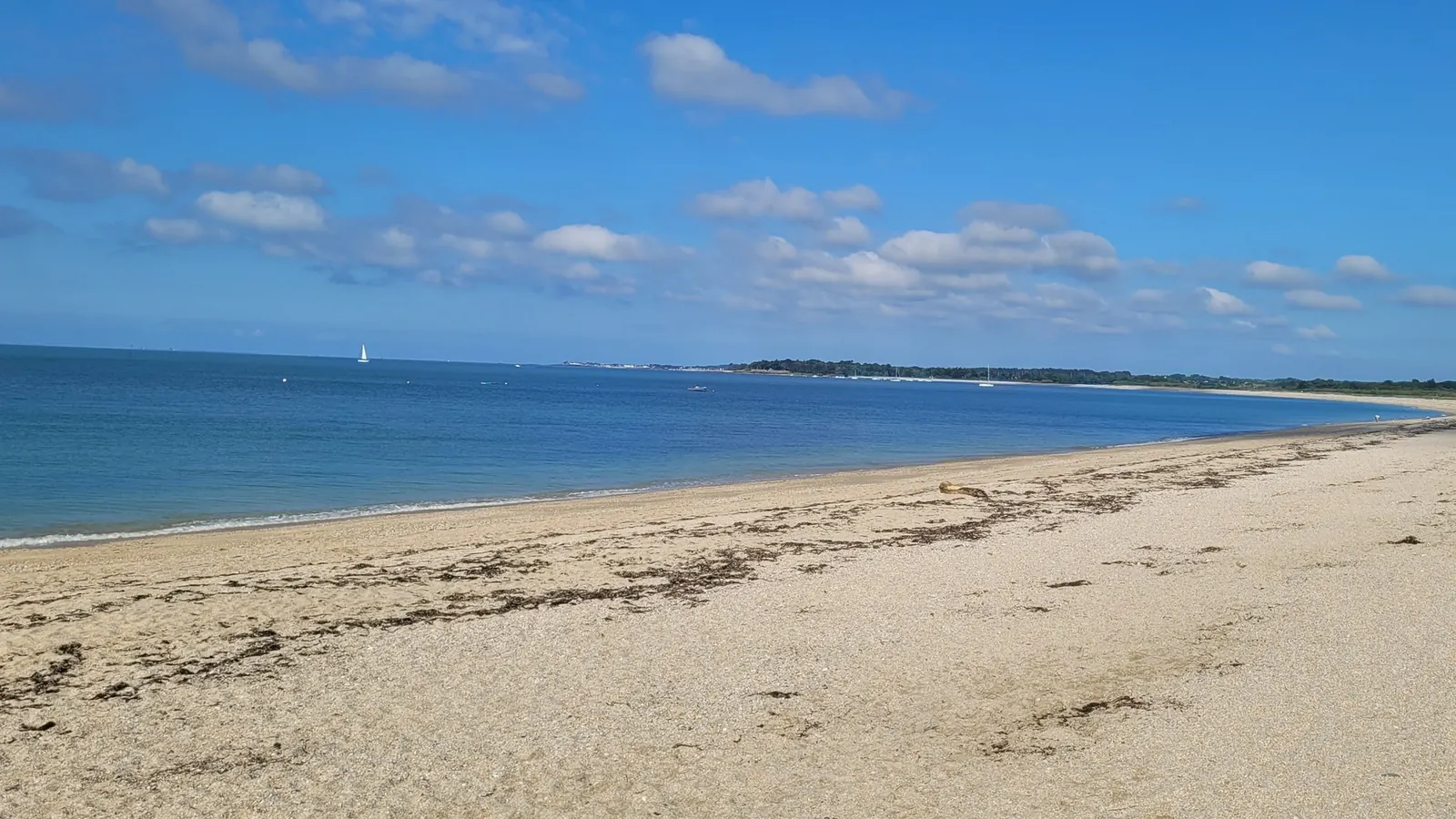 Une plage de sable déserte sous un ciel bleu, un matin de mai