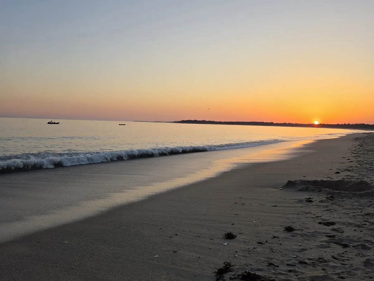 Coucher de soleil sur la plage de Landrezac, une vague sur le sable
