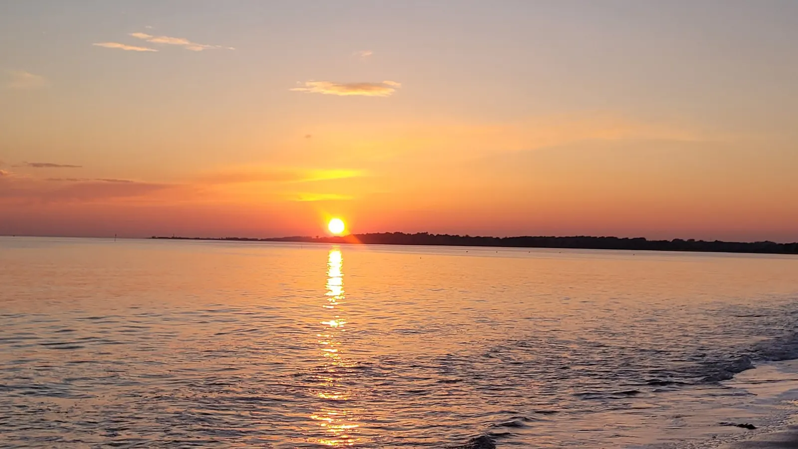 Le soleil se couche sur la mer, son reflet sur l’eau